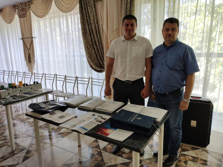 Дмитрий Иванов (справа) на партнерской встрече у информационного стенда компании «Изолятор»